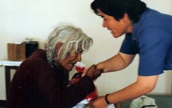Promotora de la salud ayudando a una anciana en Perú