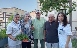 La auxiliar de enfermería Montserrat Batllori y la terapeuta ocupacional del Centre Maria Gay, Nerea Marín, junto a personas residentes aficionadas a la horticultura.